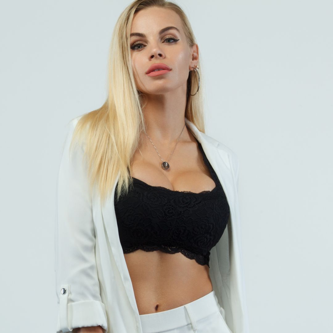 woman wearing a black short top under a white jacket